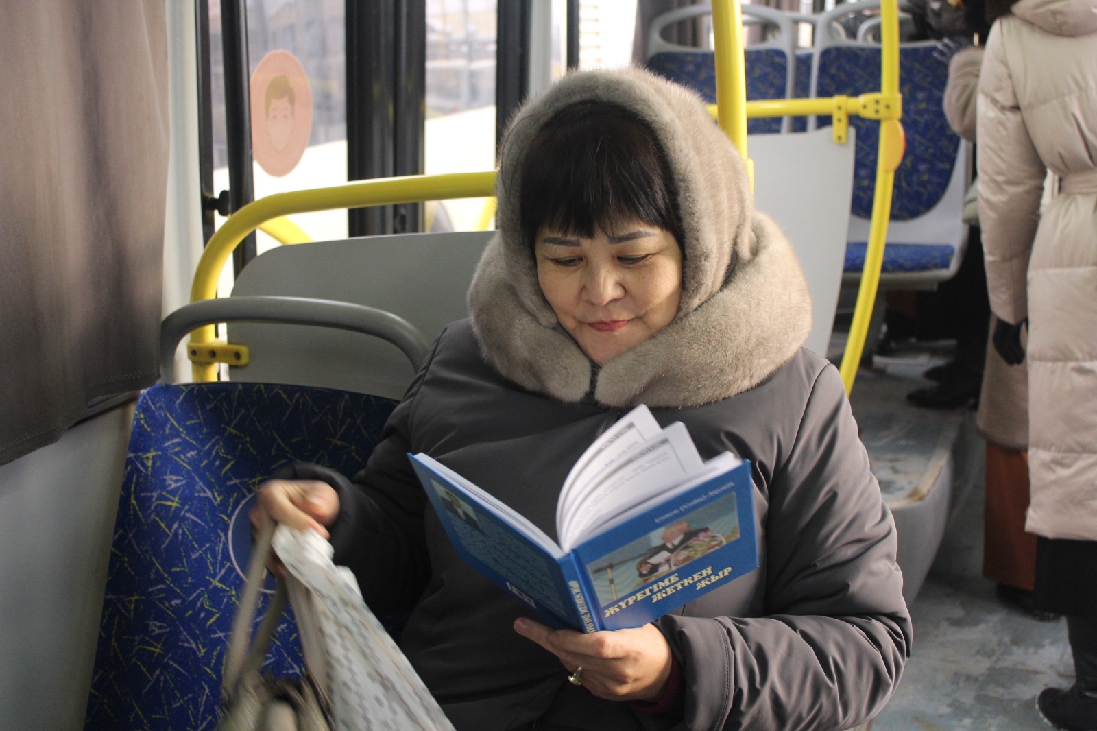 Автобуста кітап оқиды